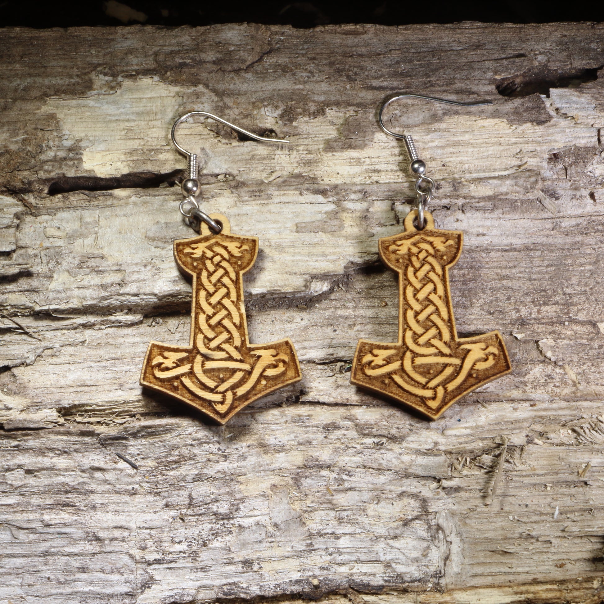 Handcrafted wooden Thor's Hammer (Mjölnir) dangle earrings featuring an engraved Celtic knot design on lightweight wood with hypoallergenic .925 sterling silver hooks. Perfect for Norse mythology fans, Viking enthusiasts, pagan jewelry lovers, and Celtic-inspired accessories.