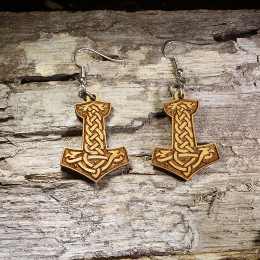 Handcrafted wooden Thor's Hammer (Mjölnir) dangle earrings featuring an engraved Celtic knot design on lightweight wood with hypoallergenic .925 sterling silver hooks. Perfect for Norse mythology fans, Viking enthusiasts, pagan jewelry lovers, and Celtic-inspired accessories.