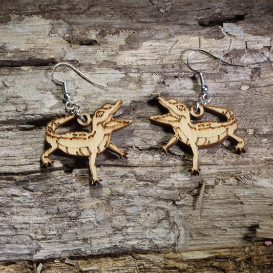 Handmade baby alligator wooden dangle earrings featuring adorable laser-cut green baby alligators with detailed engraved accents. Lightweight reptile earrings crafted from wood with hypoallergenic .925 sterling silver hooks, perfect for alligator lovers, reptile enthusiasts, swamp wildlife fans, Florida nature lovers, and unique animal jewelry collectors.