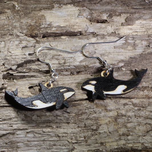 Handmade orca whale wooden dangle earrings featuring black and white killer whales with hand-painted details. Lightweight ocean wildlife earrings crafted from wood with hypoallergenic .925 sterling silver hooks, perfect for orca lovers, marine biologists, whale watchers, ocean enthusiasts, and sea life jewelry collectors.