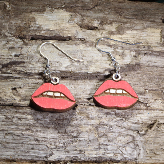 Handmade red lips wooden dangle earrings featuring bold glossy red lips with hand-painted details. Lightweight beauty-inspired earrings crafted from wood with hypoallergenic .925 sterling silver hooks, perfect for makeup lovers, beauty enthusiasts, lipstick fans, cosmetologists, salon professionals, and fun statement jewelry collectors.
