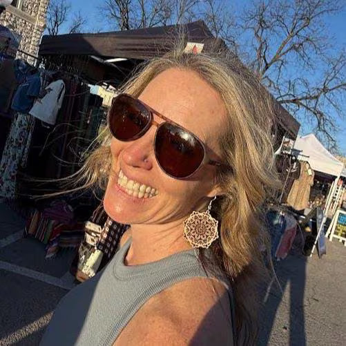Happy customer wearing handcrafted wooden mandala dangle earrings at a local art festival. This lifestyle image showcases how these lightweight geometric earrings complement casual and boho-inspired outfits while featuring hypoallergenic .925 sterling silver hooks for comfortable all-day wear.
