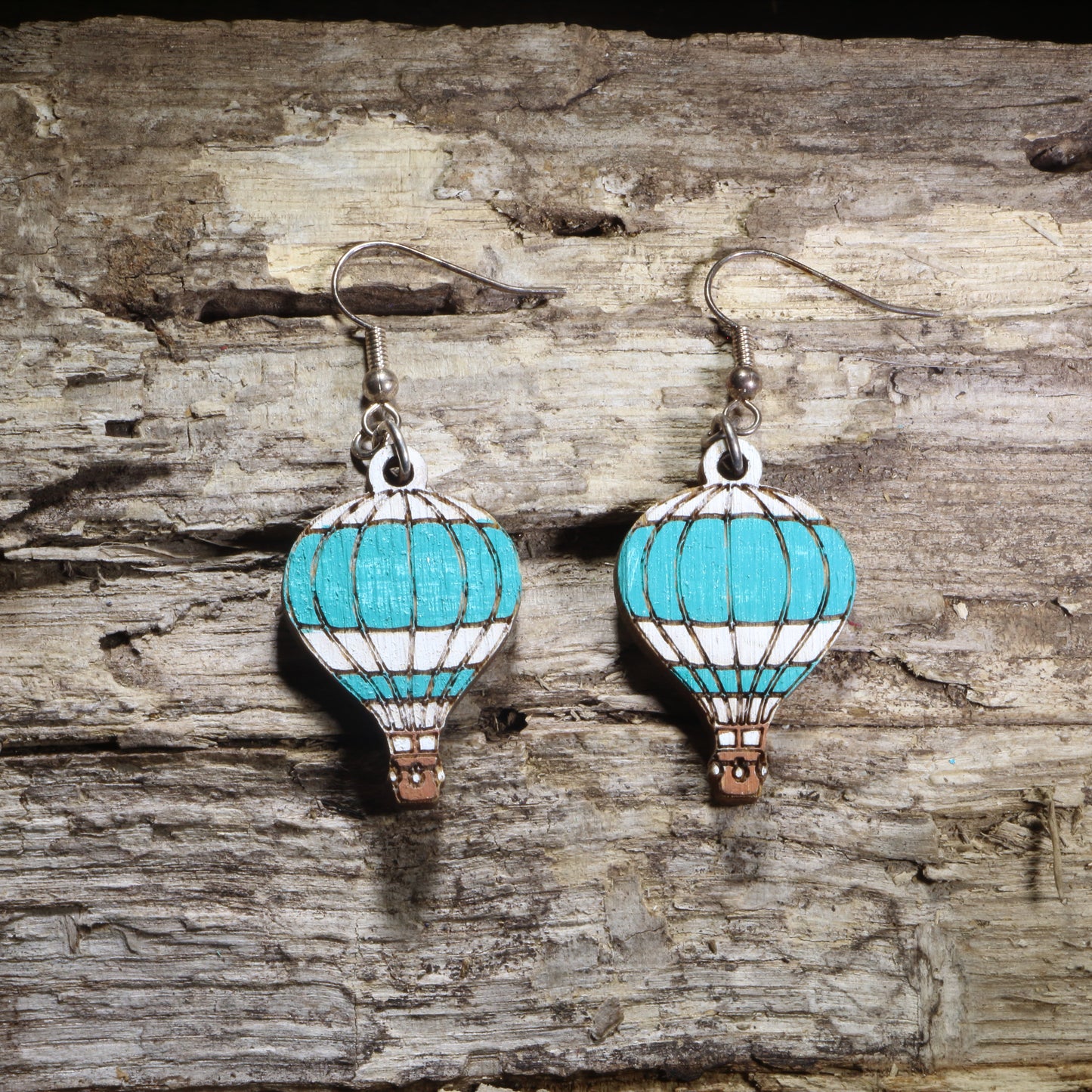 Handcrafted hot air balloon wooden dangle earrings featuring colorful hand-painted hot air balloons with engraved details. Lightweight laser-cut wooden earrings with hypoallergenic .925 sterling silver hooks, perfect for travel lovers, adventure seekers, aviation enthusiasts, wanderers, and unique handmade statement jewelry.