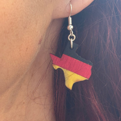 Close-up of hand-painted wooden Germany state-shaped dangle earrings featuring black, red, and gold German flag colors with hypoallergenic sterling silver hooks by Cate’s Concepts