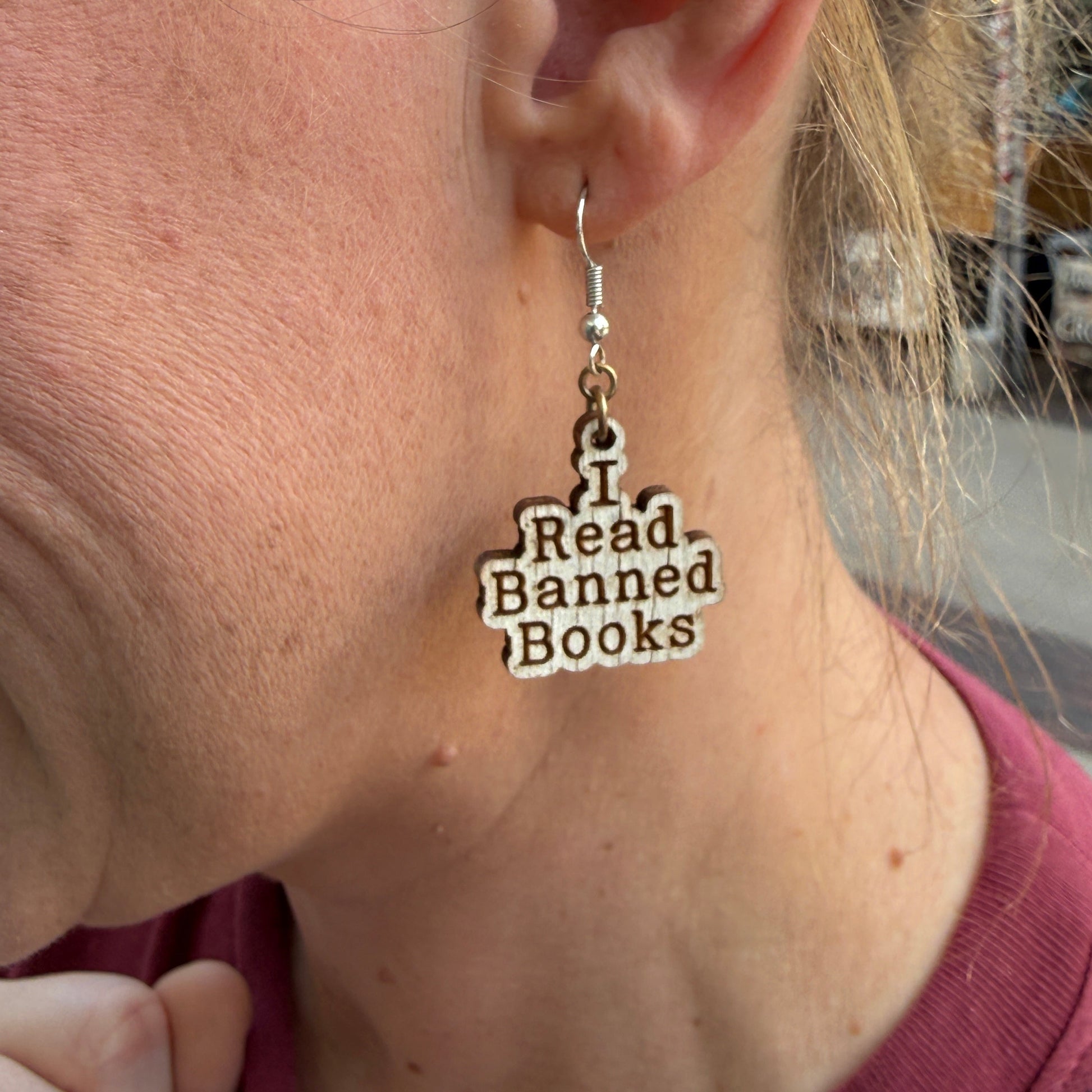 Close-up of a person wearing a necklace with 'I Read Banned Books' pendant.