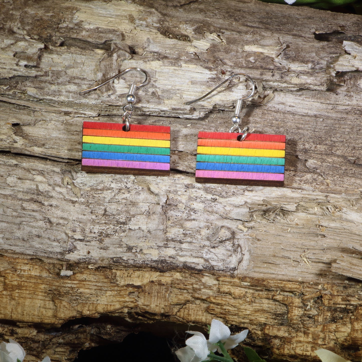 Hand-painted wooden LGBTQ Pride Flag dangle earrings featuring vibrant rainbow flag stripes, hypoallergenic sterling silver hooks, and lightweight LGBTQ+ pride jewelry for advocates, allies, and members of the queer community by Cate's Concepts.