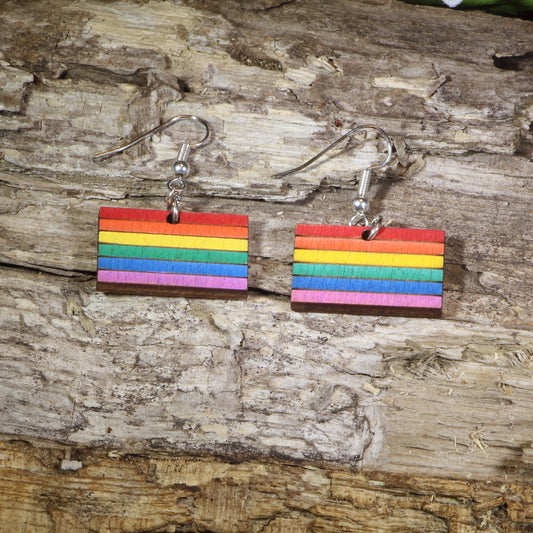 Hand-painted wooden LGBTQ Pride Flag dangle earrings featuring vibrant rainbow flag stripes, hypoallergenic sterling silver hooks, and lightweight LGBTQ+ pride jewelry for advocates, allies, and members of the queer community by Cate's Concepts.
