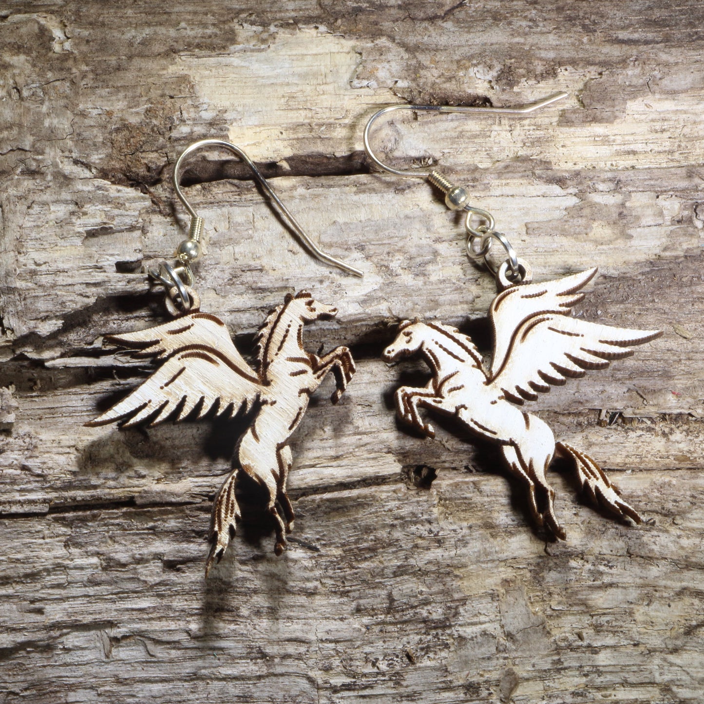Handcrafted Pegasus wooden dangle earrings featuring the mythical winged horse with detailed flowing wings and elegant hand-painted accents. Lightweight laser-cut wooden earrings with hypoallergenic .925 sterling silver hooks, perfect for mythology lovers, fantasy fans, horse enthusiasts, Greek mythology collectors, and magical-inspired jewelry.