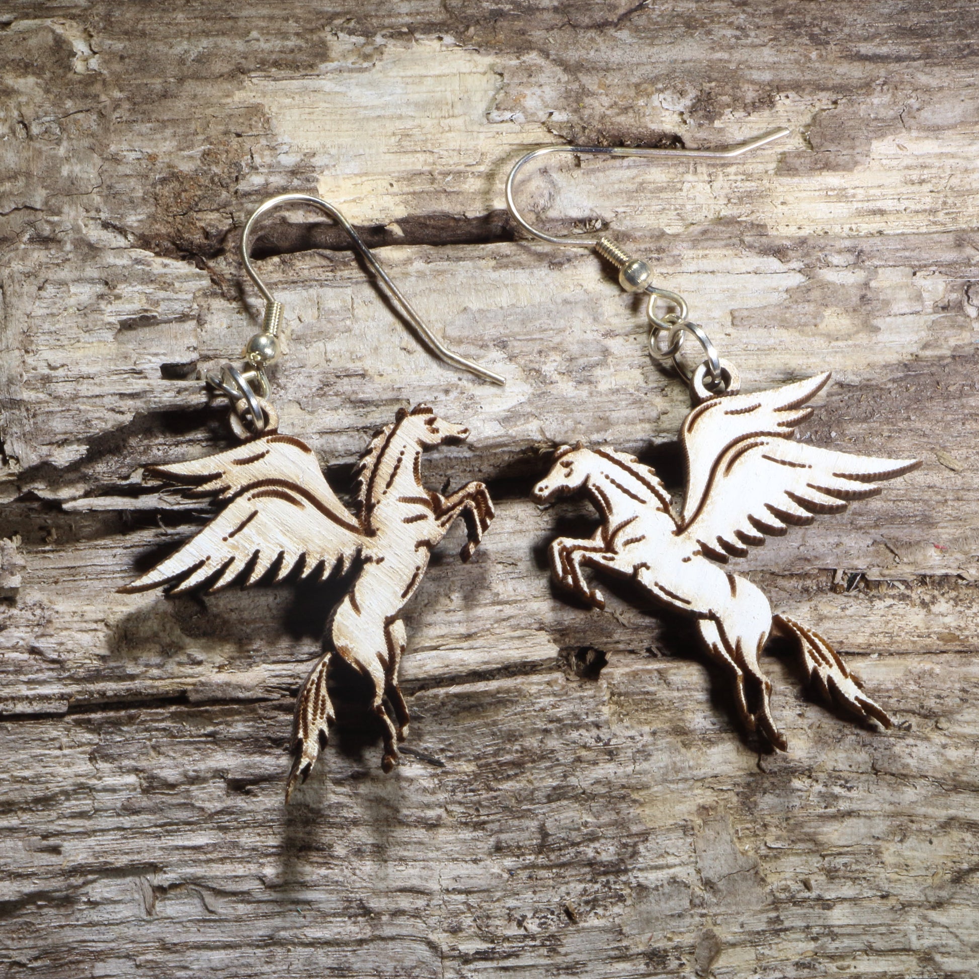Handcrafted Pegasus wooden dangle earrings featuring the mythical winged horse with detailed flowing wings and elegant hand-painted accents. Lightweight laser-cut wooden earrings with hypoallergenic .925 sterling silver hooks, perfect for mythology lovers, fantasy fans, horse enthusiasts, Greek mythology collectors, and magical-inspired jewelry.