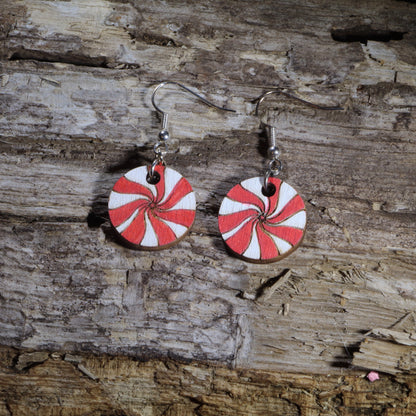 Hand-painted wooden peppermint candy dangle earrings featuring classic red and white swirled peppermint mints. Crafted from lightweight wood with hypoallergenic .925 sterling silver hooks, these festive holiday earrings are perfect for Christmas celebrations, winter parties, candy lovers, cookie exchanges, stocking stuffers, peppermint-themed outfits, and anyone who loves sweet holiday-inspired jewelry.