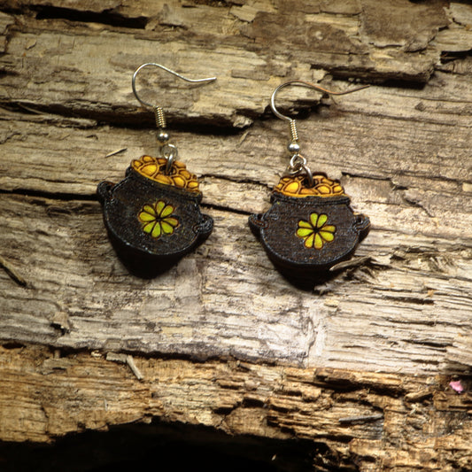 Hand-painted wooden pot of gold dangle earrings featuring a treasure-filled pot overflowing with bright gold coins inspired by Irish folklore. Crafted from lightweight wood with hypoallergenic .925 sterling silver hooks, these festive earrings are perfect for St. Patrick's Day celebrations, Irish heritage, lucky charm enthusiasts, leprechaun lovers, Celtic festivals, and anyone who enjoys whimsical Irish-inspired jewelry.