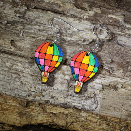 Hand-painted wooden rainbow hot air balloon dangle earrings featuring colorful stained-glass inspired balloon panels, hypoallergenic sterling silver hooks, and lightweight travel jewelry for adventure lovers, festival outfits, and rainbow accessory fans by Cate's Concepts.