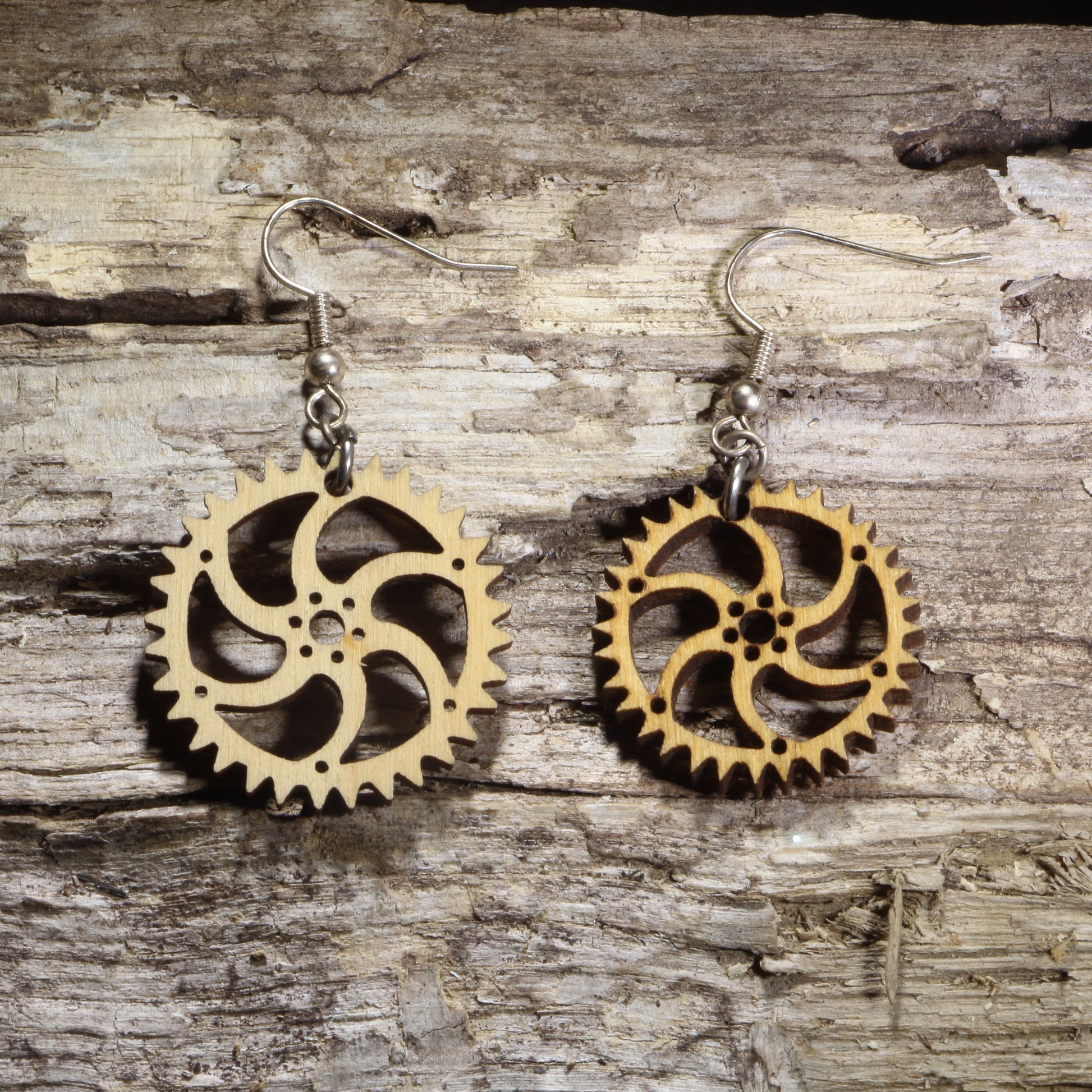 Handcrafted steampunk gear wooden dangle earrings featuring intricate interlocking gears inspired by Victorian industrial design. Lightweight laser-cut wooden earrings with hypoallergenic .925 sterling silver hooks, perfect for steampunk enthusiasts, engineers, makers, cosplay, science fiction fans, and vintage-inspired statement jewelry.