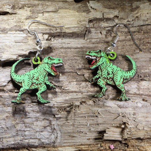 T-Rex wooden dangle earrings featuring detailed Tyrannosaurus rex dinosaurs available in green, finishes. Lightweight dinosaur earrings with hypoallergenic .925 sterling silver hooks, perfect for dinosaur lovers, paleontology fans, science teachers, museum enthusiasts, and prehistoric-themed gifts.