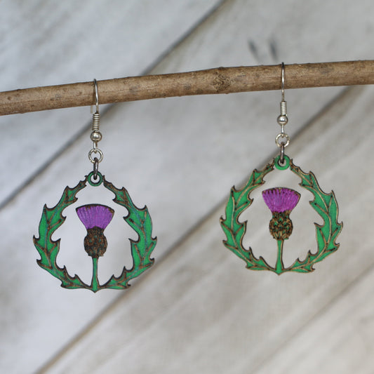 Hand-painted wooden thistle dangle earrings with Celtic Scottish flower design and hypoallergenic sterling silver hooks, lightweight botanical jewelry for heritage lovers and nature-inspired style by Cate’s Concepts
