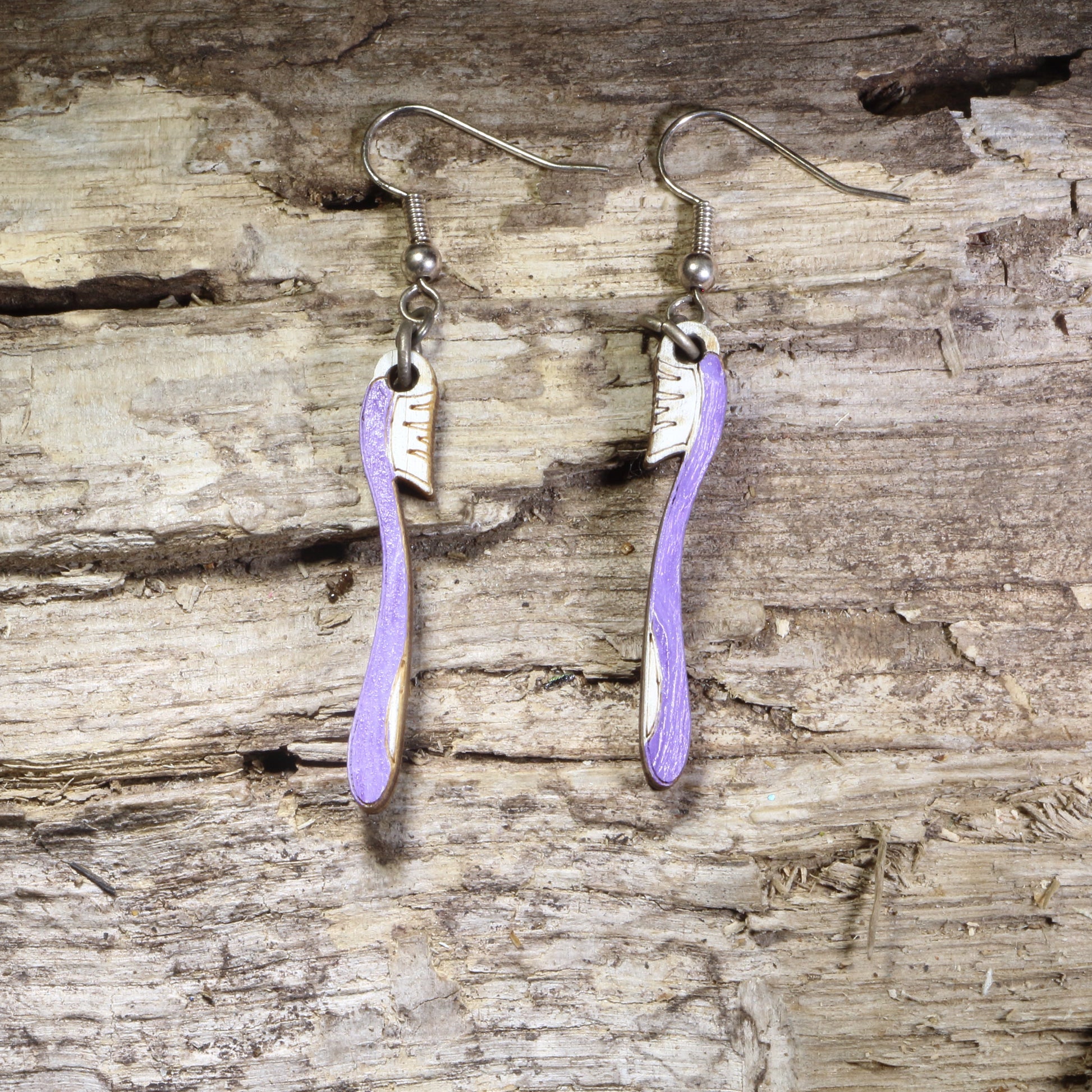 Handcrafted toothbrush wooden dangle earrings featuring colorful hand-painted toothbrushes with detailed bristles. Lightweight laser-cut wooden earrings with hypoallergenic .925 sterling silver hooks, perfect for dental hygienists, dentists, dental assistants, dental students, oral health professionals, and fun dental-themed jewelry.