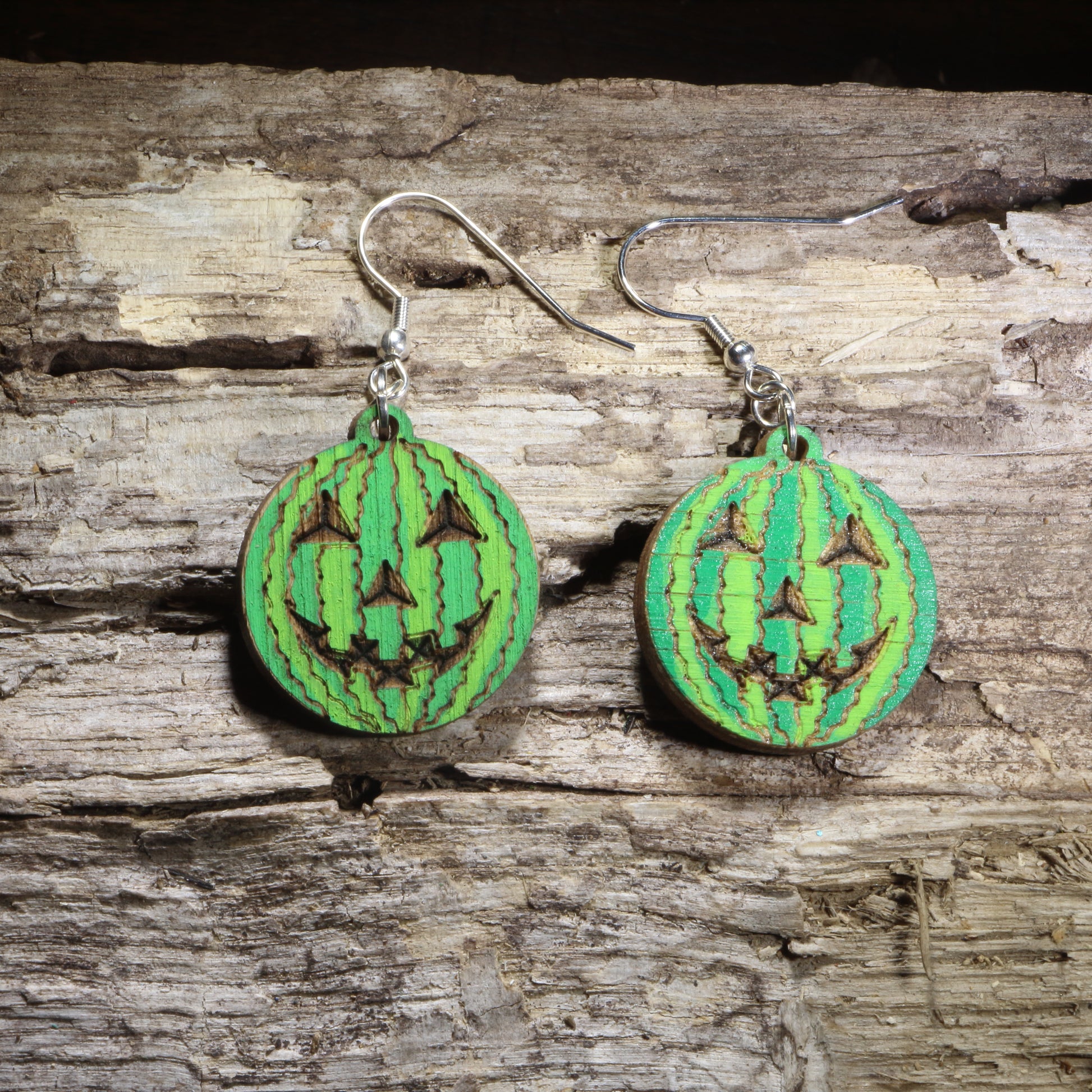 Handcrafted Watermelon Jack-o'-Lantern wooden dangle earrings featuring a carved watermelon with a jack-o'-lantern face. Lightweight laser-cut wooden earrings with hypoallergenic .925 sterling silver hooks, perfect for Summerween celebrations, Halloween lovers, watermelon fans, quirky seasonal fashion, and unique novelty jewelry.