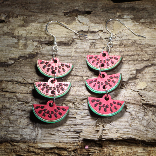 Watermelon slice chain wooden dangle earrings featuring three connected hand-painted watermelon wedges with bright red fruit, green rinds, and black seed details. Lightweight summer fruit earrings with hypoallergenic .925 sterling silver hooks, perfect for watermelon lovers, summer outfits, picnics, farmers markets, and fun food-themed jewelry.