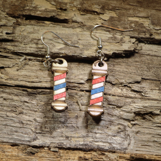 Hand-painted wooden barber pole dangle earrings featuring the iconic red, white, and blue barber pole design. Crafted from lightweight wood with hypoallergenic .925 sterling silver hooks, these fun barber earrings are perfect for barbers, hairstylists, cosmetologists, beauty school students, salon owners, and anyone who loves unique profession-inspired jewelry.