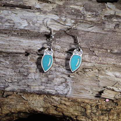 Hand-painted wooden Christmas light bulb dangle earrings featuring classic teal holiday light bulbs with white tops. Crafted from lightweight wood with hypoallergenic .925 sterling silver hooks, these festive Christmas earrings are perfect for holiday parties, Christmas decorating, winter celebrations, stocking stuffers, Christmas light enthusiasts, and anyone who loves cheerful holiday jewelry inspired by classic Christmas lights.
