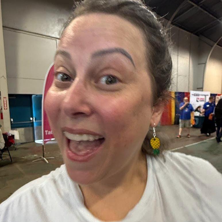 Womanwearing hand-painted wooden upside-down pineapple dangle earrings in a real-world setting. This lifestyle photo demonstrates the earrings' scale, movement, and eye-catching tropical design, making them a fun accessory for vacations, cruises, festivals, and casual summer style.