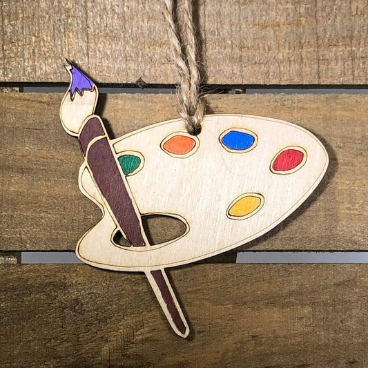 Hand-painted wooden artist Christmas ornament featuring creative art-themed details like paintbrush and palette design, unique holiday decor gift for artists and creative enthusiasts by Cate’s Concepts