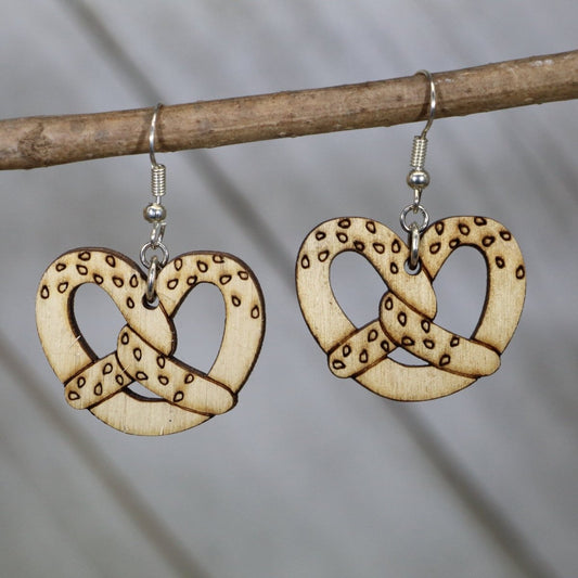 Hand-painted wooden Bavarian pretzel dangle earrings featuring a classic twisted pretzel design with salt detail accents and hypoallergenic sterling silver hooks, lightweight jewelry for food lovers and Oktoberfest enthusiasts by Cate’s Concepts
