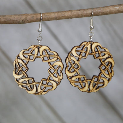 Hand-painted wooden Celtic heart dangle earrings featuring an intricate knot circle design with interwoven lines and hypoallergenic sterling silver hooks, lightweight jewelry for Celtic heritage lovers and boho style enthusiasts by Cate’s Concepts