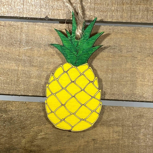 Hand-painted wooden Hawaiian pineapple Christmas ornament featuring a detailed tropical fruit design with textured pattern and leafy crown, festive holiday decor for beach lovers and tropical style enthusiasts by Cate’s Concepts