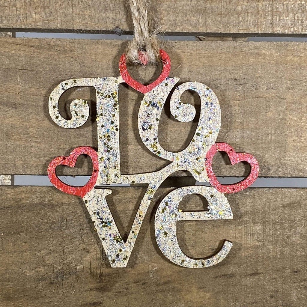 Hand-painted wooden LOVE Christmas ornament featuring bold romantic lettering with clean lines and decorative styling, meaningful holiday decor for couples and Valentine-inspired seasonal displays by Cate’s Concepts
