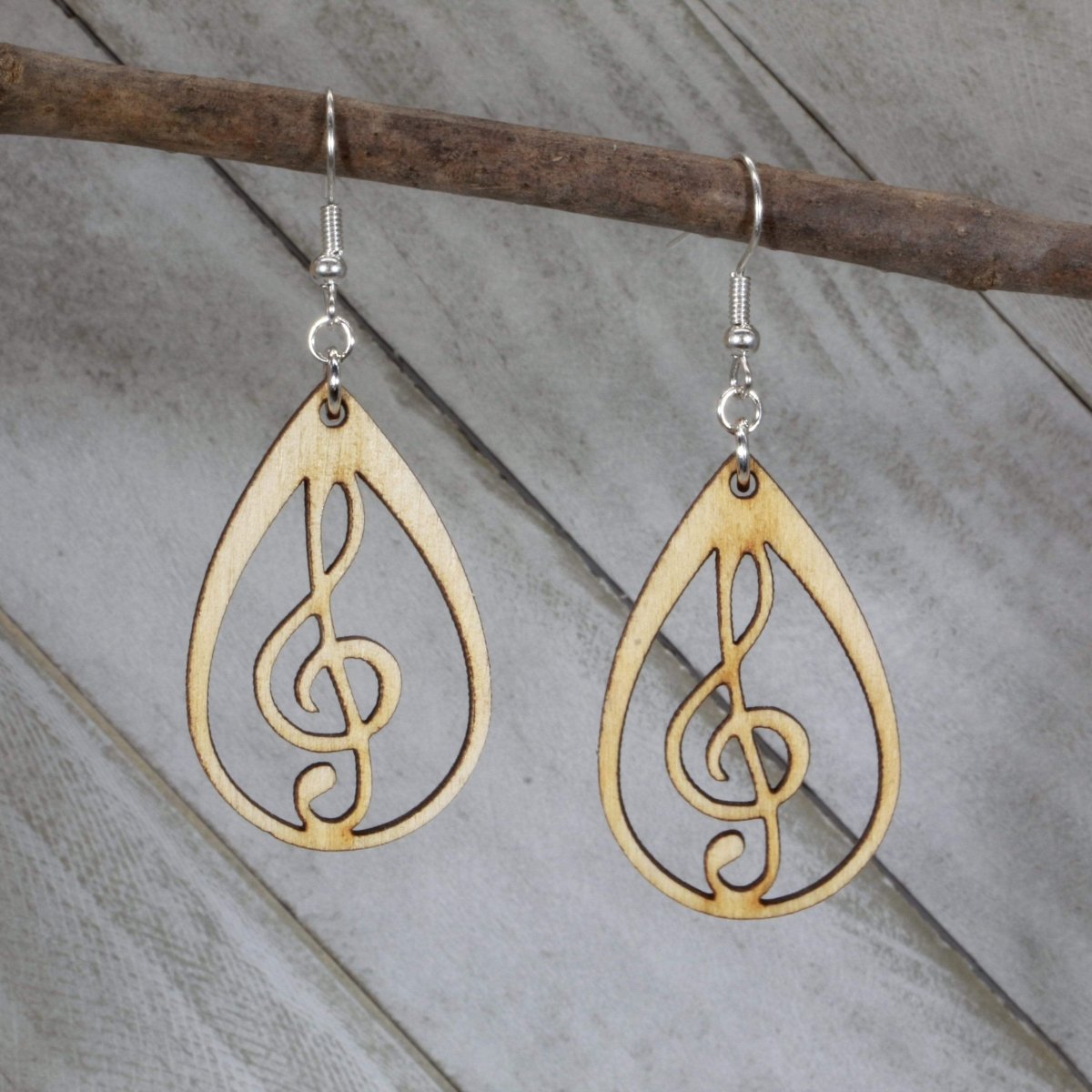 Hand-painted wooden music heart earrings featuring a treble clef heart design with detailed musical lines and hypoallergenic sterling silver hooks, lightweight jewelry for music lovers and band enthusiasts by Cate’s Concepts