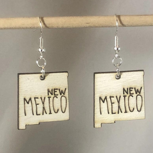 Hand-painted wooden New Mexico state dangle earrings featuring a state-shaped design with bold Southwest-inspired detailing and hypoallergenic sterling silver hooks, lightweight jewelry for New Mexico locals and desert style enthusiasts by Cate’s Concepts
