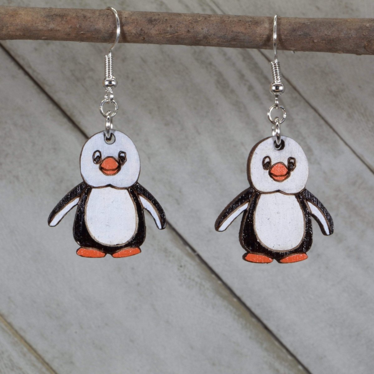 Hand-painted wooden penguin dangle earrings featuring a cute black and white penguin design with rounded body and playful details and hypoallergenic sterling silver hooks, lightweight jewelry for animal lovers and winter style enthusiasts by Cate’s Concepts