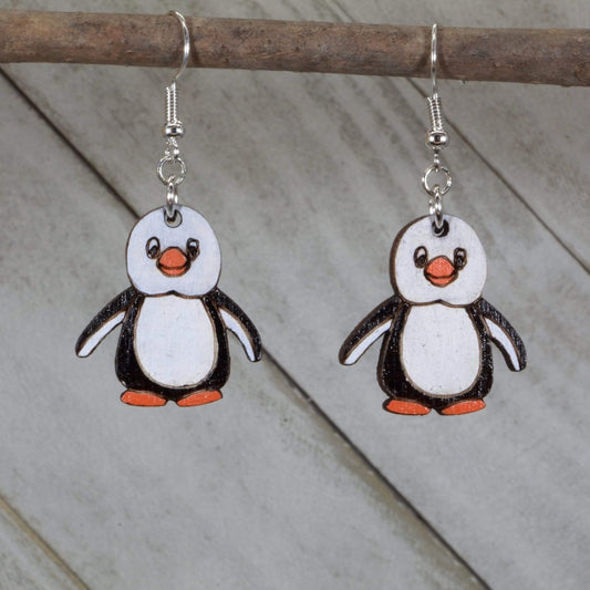 Hand-painted wooden penguin dangle earrings featuring a cute black and white penguin design with rounded body and playful details and hypoallergenic sterling silver hooks, lightweight jewelry for animal lovers and winter style enthusiasts by Cate’s Concepts