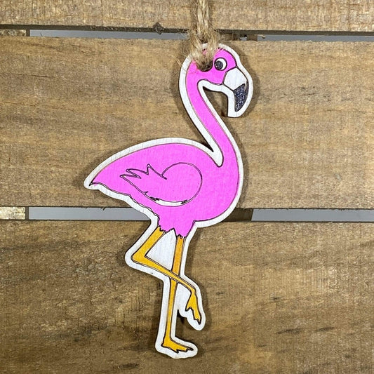 Hand-painted wooden pink flamingo Christmas ornament featuring a vibrant tropical bird design with curved neck and detailed feathers, festive holiday decor for beach lovers and tropical style enthusiasts by Cate’s Concepts