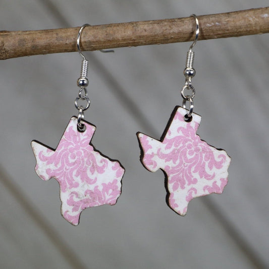 Hand-painted wooden Texas floral dangle earrings featuring a pink state-shaped design with blooming flower accents and hypoallergenic sterling silver hooks, lightweight jewelry for Texas lovers and state pride enthusiasts by Cate’s Concepts
