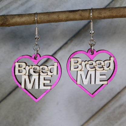Hand-painted pink wooden “Breed Me” dangle earrings with bold adult humor lettering and hypoallergenic sterling silver hooks, cheeky novelty statement jewelry earrings for playful edgy style